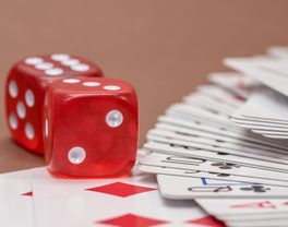 Two red dice resting beside a spread of cards
